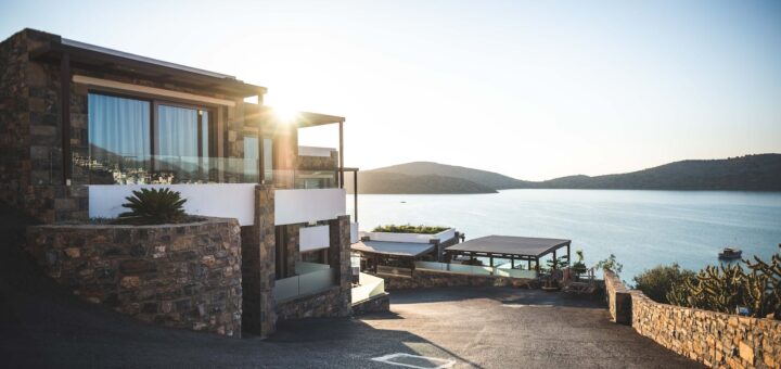 Sun Piercing of Brown Concrete House Near Sea